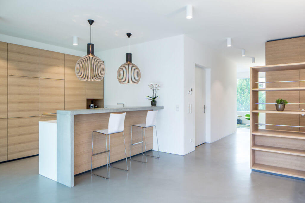 Kleine Wohnküche mit Bar aus Beton und Holz.