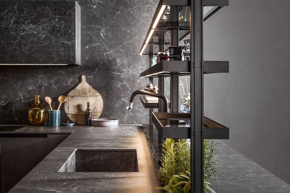Zeitlose Designküche mit dunklen Laminam-Keramikfronten, offener Kräuterwand und natürlichen Holzelementen.