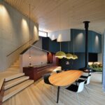 Offene Wohnküche mit Esstisch, Kochinsel und moderner Designbeleuchtung